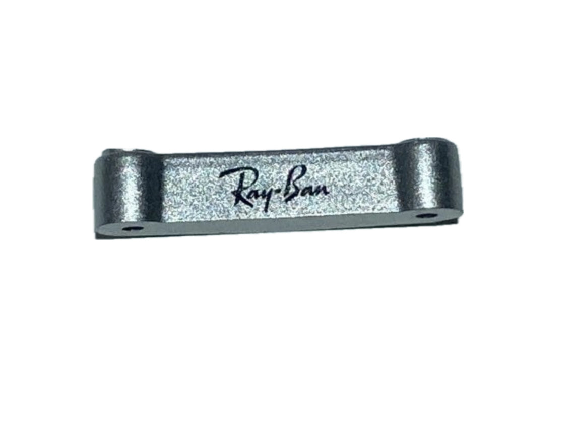 A silver-colored folding bridge bar for Rayban RB4105 sunglasses with the Ray-Ban logo engraved on it.