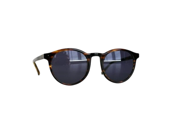 A pair of sunglasses with a tortoiseshell pattern frame, lying on a white surface.