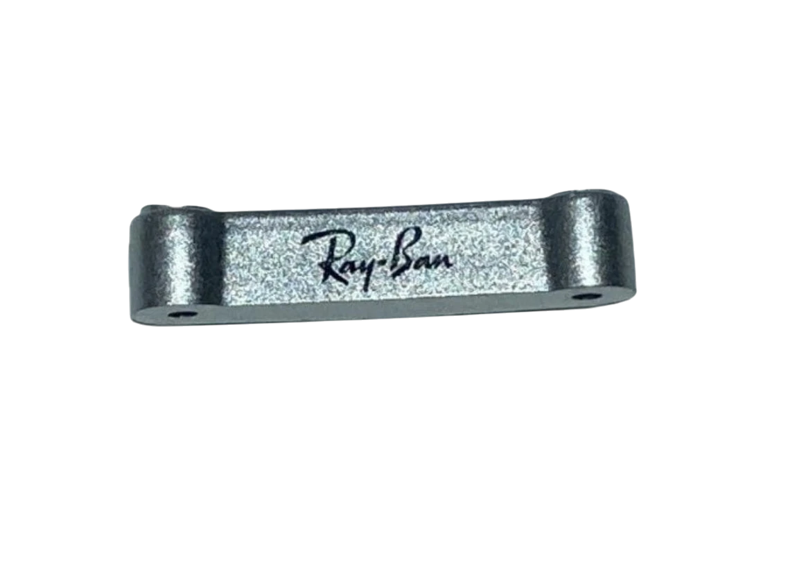 A silver-colored folding bridge bar for Rayban RB4105 sunglasses with the Ray-Ban logo engraved on it.